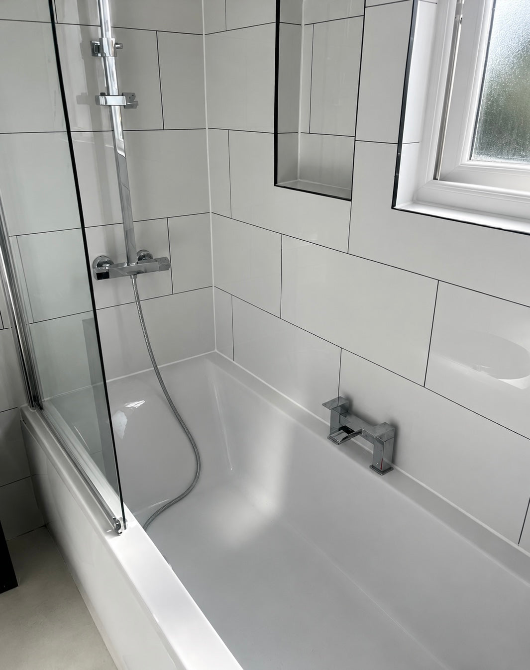 White polished tiles in a bathroom with dark grey grout