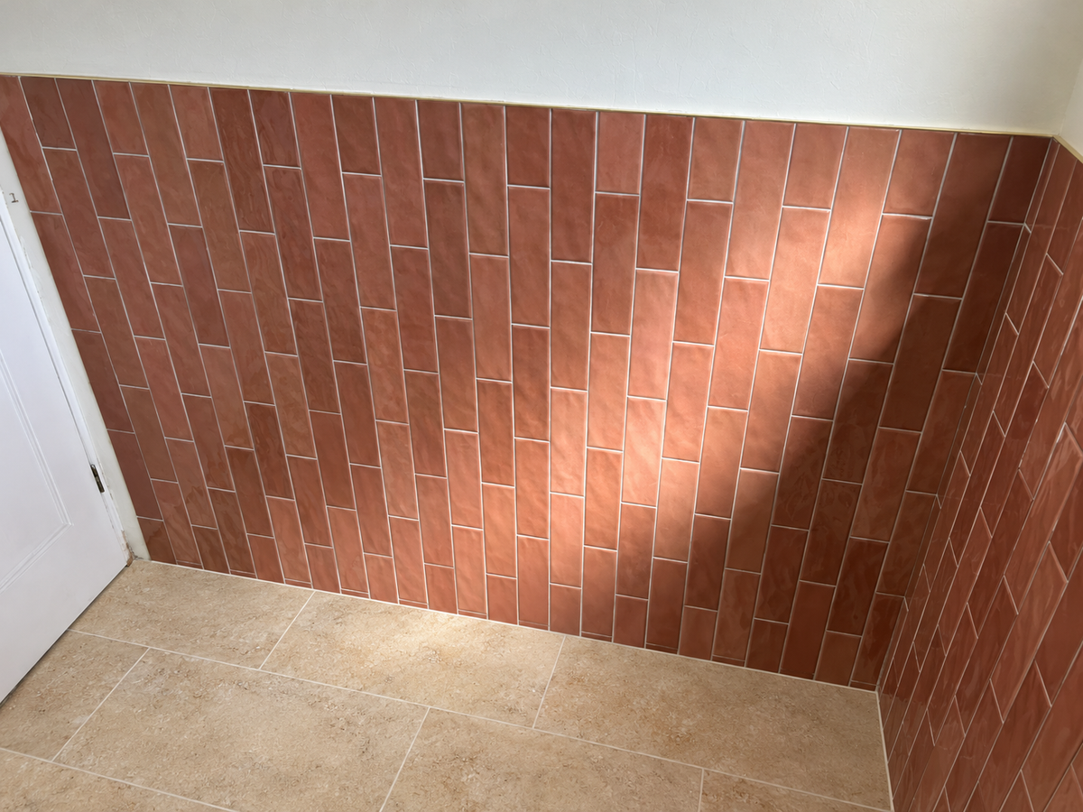 Coral tiles on walll with a sand colour floor tiles 