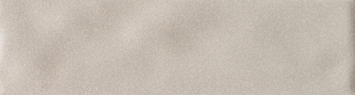 A close-up of a light warm gray or beige textured surface, likely a material or color swatch.